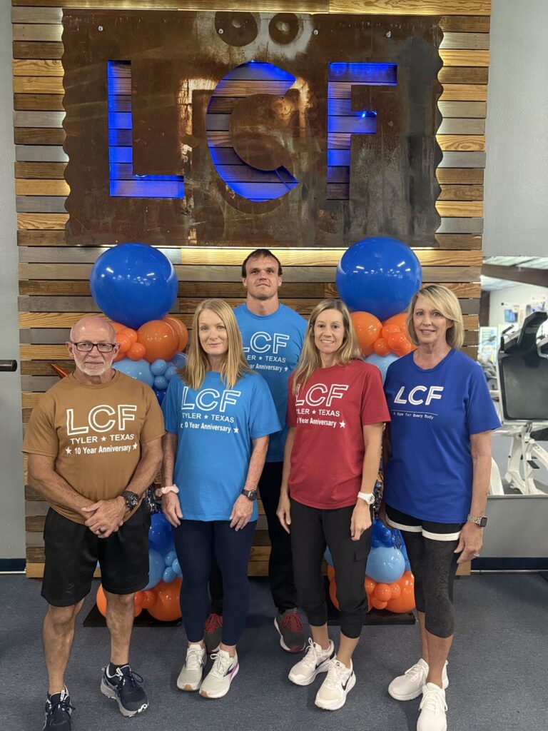 Life Changing Fitness trainers in front of the LCF sign