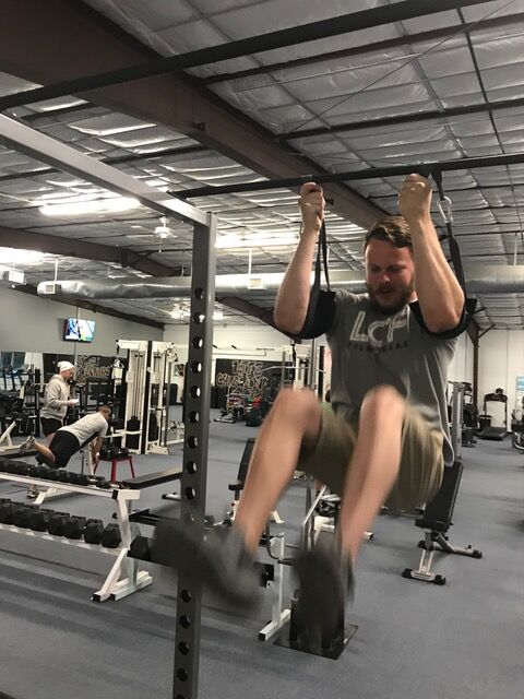 A member doing hanging leg raises